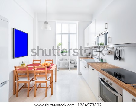 Indoor mockup of a stylish bright kitchen with white cabinets. Spacious modern interior with wooden table, chairs, picture frame and big windows