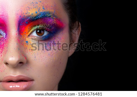 Close up view of female face with bright multicolored fashion makeup. Holi indian color festival inspired. Studio macro shot. Copy space. Royalty-Free Stock Photo #1284576481