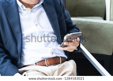 Businessman Using Smartphones While Sitting on a Chair
