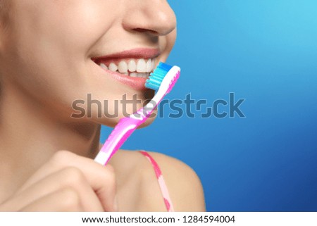 Young woman with toothbrush on color background, closeup. Space for text