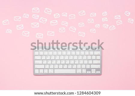 Keyboard on a pink background and flying envelopes. Concept global network, e-mail, correspondence, many e-mails. Flat lay, top view.
