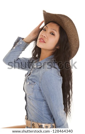 A woman in her denim dress and her cowgirl hat.