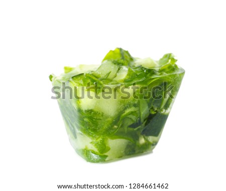 Ice cube with cucumber slices and herbs on white background