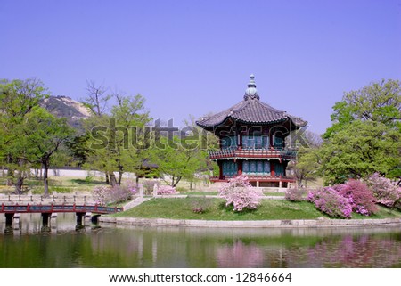 A bridge leads to an old pavillion by the water at Kyoungbok Palace in Seoul, Korea. Royalty-Free Stock Photo #12846664