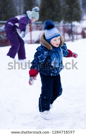 active winter holiday - cute little boy skating on an ice rink