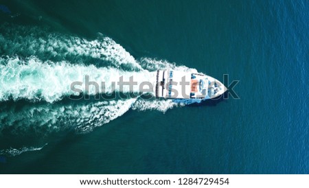 Aerial bird's eye view photo taken by drone of boat cruising deep blue sea