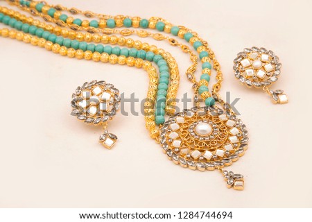 Indian gold Jewelry with stones Earrings, Bangles, neclace, Bridal traditional Designer wear colorful on white background