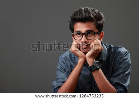 Young man of Indian origin with a thinking expression Royalty-Free Stock Photo #1284753235
