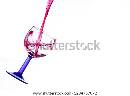 red wine pouring in a wineglass isolated on a white ackground
