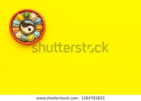 Buddhist symbol. Yin Yang symbol on yellow background top view copy space
