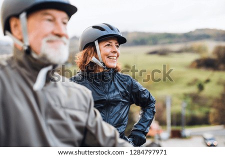 Active senior couple with electrobikes standing outdoors on a road in nature. Royalty-Free Stock Photo #1284797971