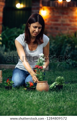 evening scene of senior woman transplanting seedlings in her garden