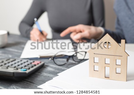 Signing a real estate contract between a realtor and a client. Mortgage loan, home insurance.