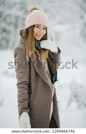 Image of happy blonde girl in hat on walk in winter forest