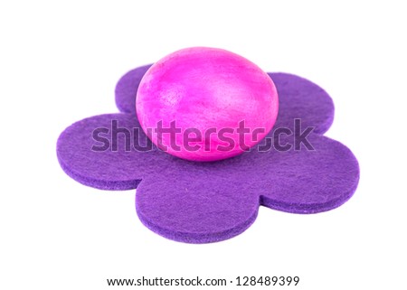 Easter egg on the violet flower, on a white background