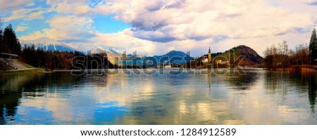 Panoramic view of Bled lake and castle with cloudy sky and snowy mountains, Slovenia