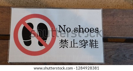 A warning sign for people to follow that no shoes are allowed in this area or please take of your shoes before entering this place/area.The place's owner wanted to keep this place/area clean.  