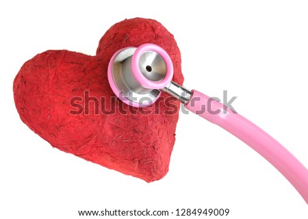 A stethoscope and a handmade red paper mache heart. Closeup, isolated on white background. Medicine and health concept.  