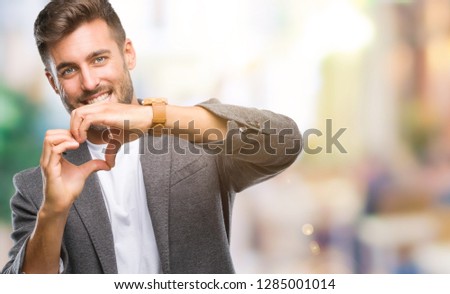 Young handsome business man over isolated background smiling in love showing heart symbol and shape with hands. Romantic concept.