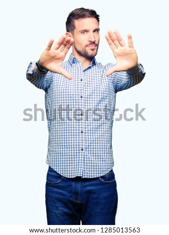 Handsome business man with blue eyes Smiling doing frame using hands palms and fingers, camera perspective
