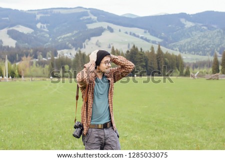A young boy travels in the mountains with a camera
