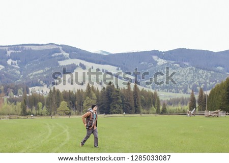 A young boy travels in the mountains with a camera
