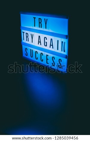 try try again success message on lightbox in the dark, motivational concept