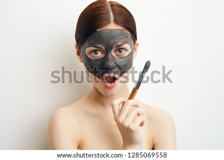 woman surprised in a cosmetic mask of clay