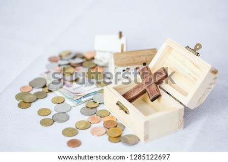wooden cross in wood box with wood model, money and coins on white background, conceptual christian image show Jesus is the most important in human life, Jesus is center of  christian family.