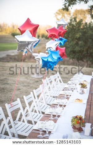 Red and blue stars birthday balloons and holiday table
