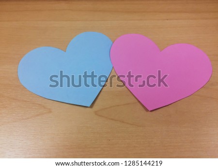 2 hearts combined into one, pink and blue hearts on a classic wooden background