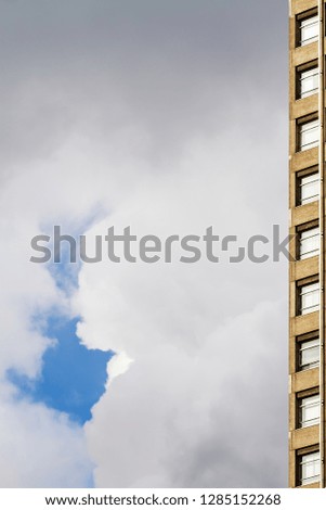 picture of a corner of a high rise with clouded sky