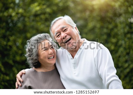 Portrait of Asian Senior Couple in casual laughing over green nature at park outdoor. Happy smiling Elderly man, woman enjoying with positive emotions at garden. People Health care, Family Lifestyle Royalty-Free Stock Photo #1285152697