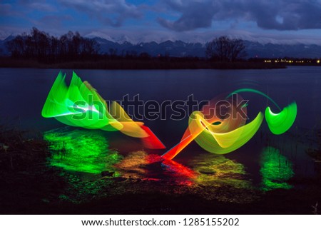 Light painting colors with reflection in the water, with mountains in the background