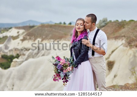 Valentine's day loving couple in nature hugs and kisses, man and woman love each other. Mountains of Cappadocia in Turkey beautiful couple celebrates Valentines day, lover couple mountains background