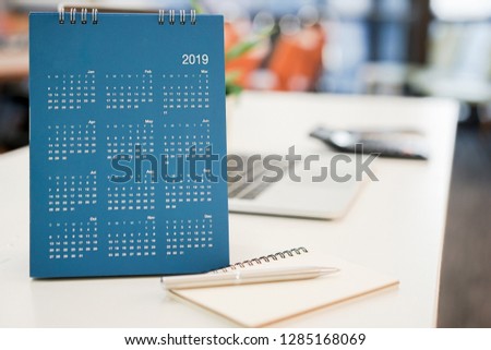 close up blue color calendar 2019  standing on white table at office room for make appointment or remind important date , workplace with object concept