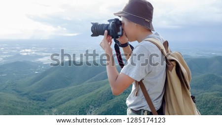 Photographer using Camera DSLR, Digital Single Lens Reflex take a photo Mountain and blue sky. Traveling Concept. Hiker concept.