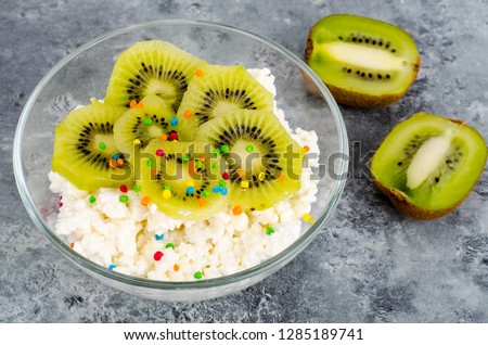 Cottage cheese with kiwi in glass bowl isolated on white background. Studio Photo