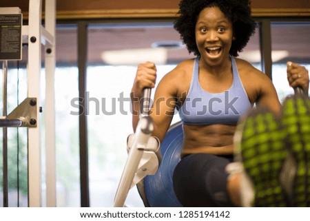 Mid-adult woman using an abdominal machine at a gym.