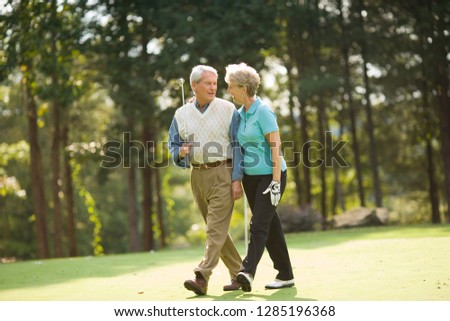 Older couple walking on golf course