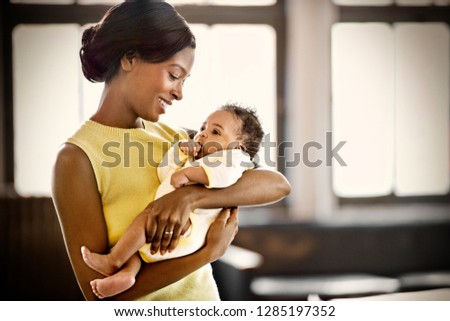 Smiling young mother holding her baby.
