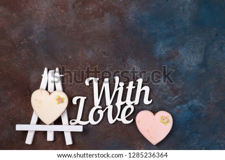 Cookies in the form of a heart in the icing on the easel as a picture on stone with copy space, flat lay. Happy Valentines Day