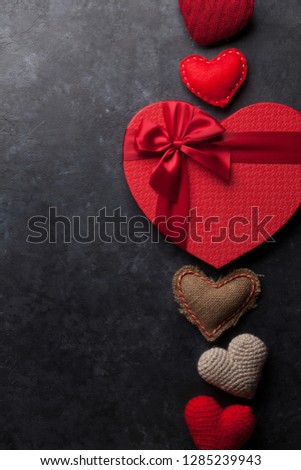 Valentine's day greeting card with handmaded heart toys and love gift box on stone background. Top view with space for your greetings. Flat lay