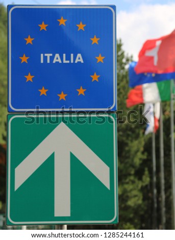 blue road sign indicating the Italian state border