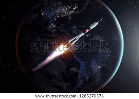 The rocket flies in space against the backdrop of the earth. The concept of space exploration, satellite launch, flight to the moon, free internet. Elements of this image furnished by NASA.