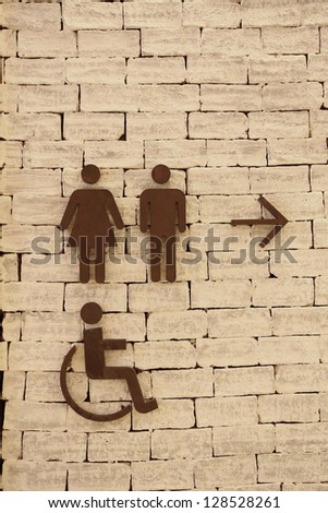 Toilet signs on the old brick wall
