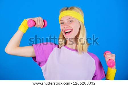 Girl exercising with dumbbell. Fitness instructor hold little dumbbell blue background. How to get toned physique. Beginner dumbbell exercises. Ultimate upper body workout for women. Fitness concept.