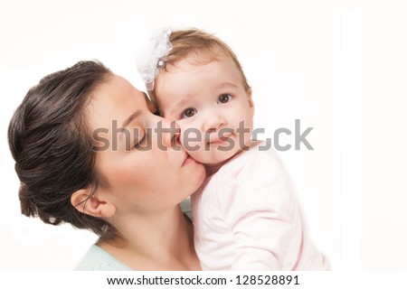 Isolated mother kissing her baby girl on white background