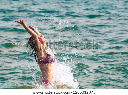 A mature woman is jumping in the water