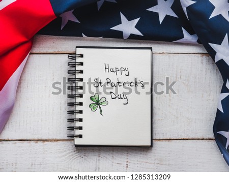 St.Patrick's Day. Beautiful card. Notepad with congratulatory inscription. Isolated background, close-up, top view, wooden surface. Congratulations for loved ones, relatives, friends and colleagues 